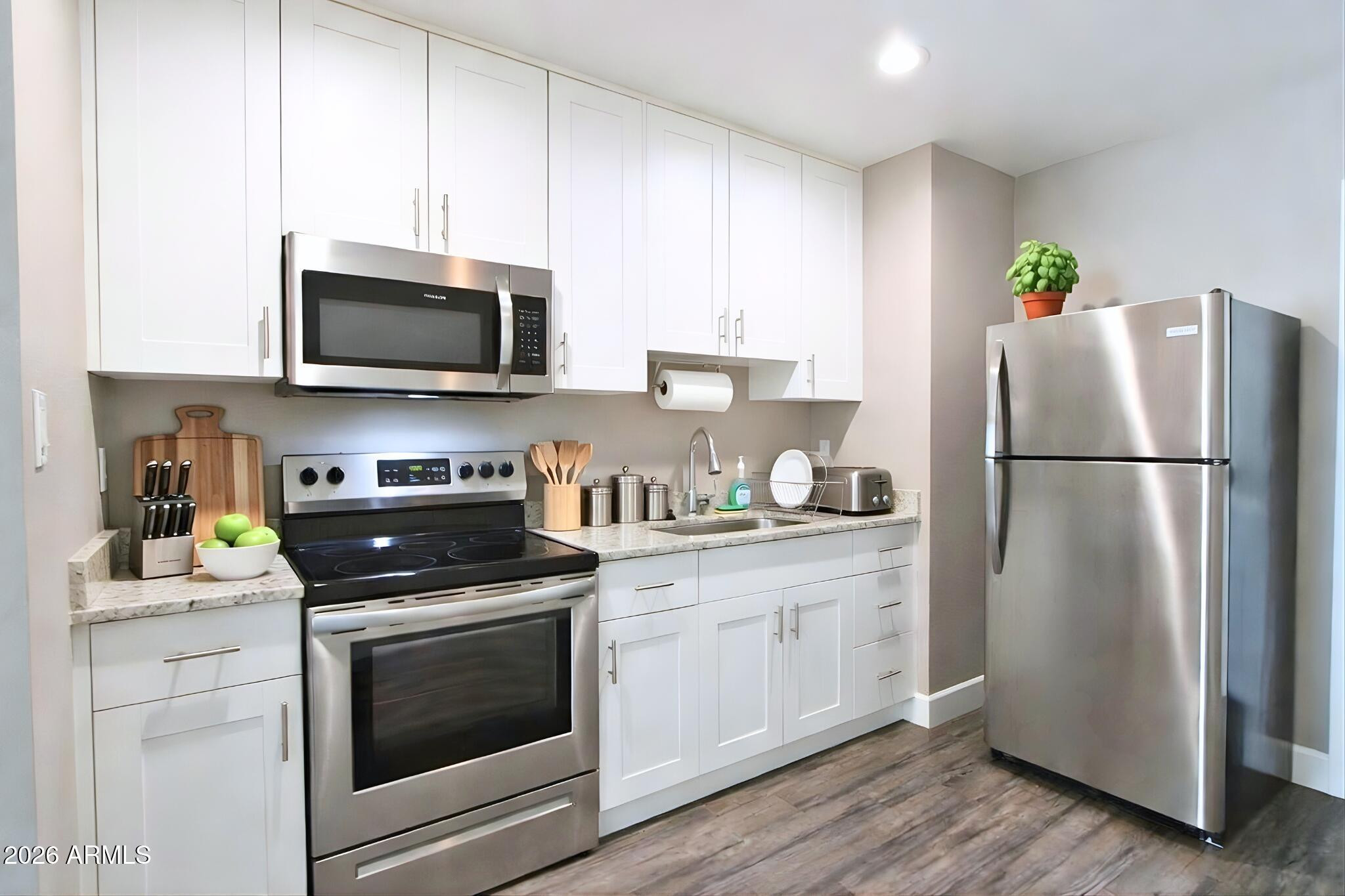 550 West 9th Street, Unit 4 Mesa, AZ 85201 - Photo 2 of 11 a kitchen with stainless steel appliances granite countertop white cabinets a stove a microwave and a refrigerator