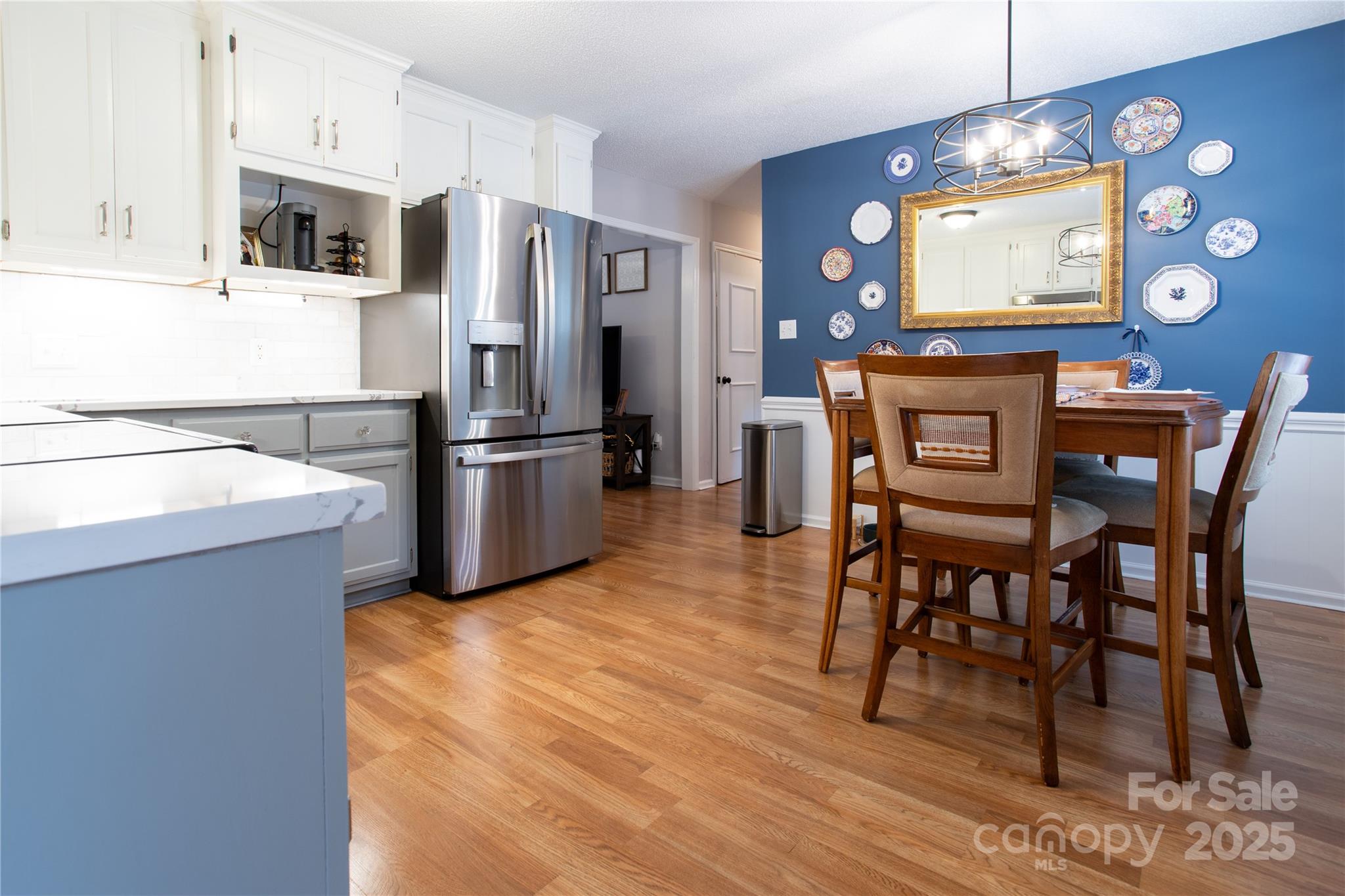 1735 Kallaramo Road Rock Hill, SC 29732 - Photo 11 of 30 a kitchen with stainless steel appliances granite countertop a refrigerator a stove top oven a sink dishwasher and a dining table with wooden floor