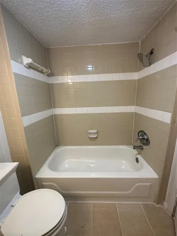a bathroom with a white bath tub and a toilet