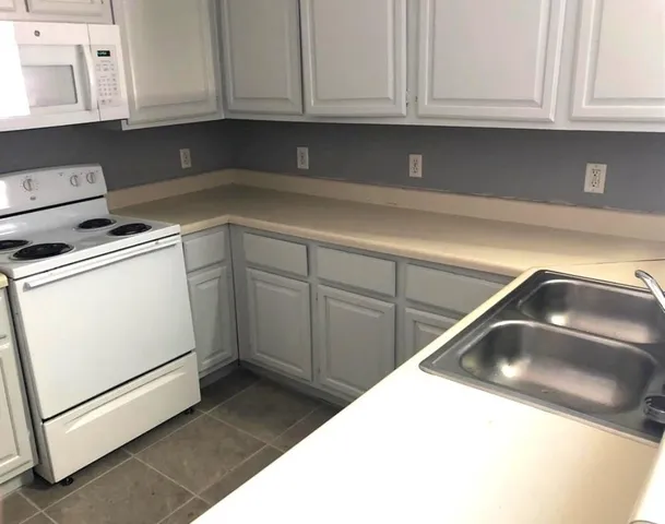a kitchen with white cabinets and white appliances