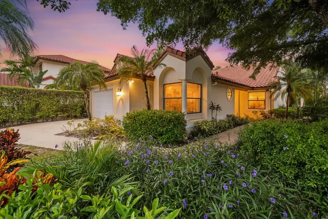 a front view of a house with a yard and potted plants