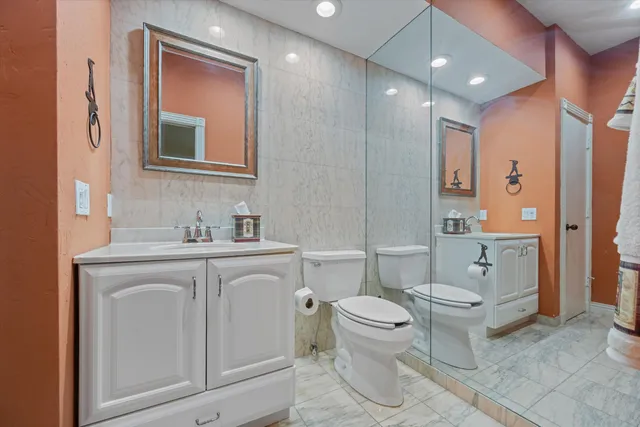 a spacious bathroom with a toilet sink and mirror