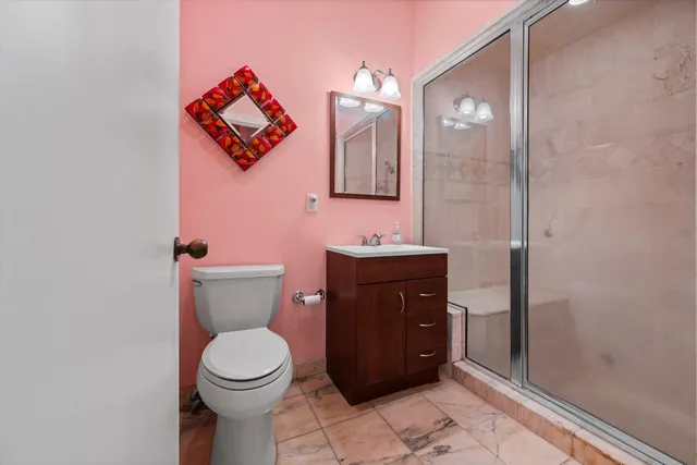 a bathroom with a toilet sink vanity and mirror