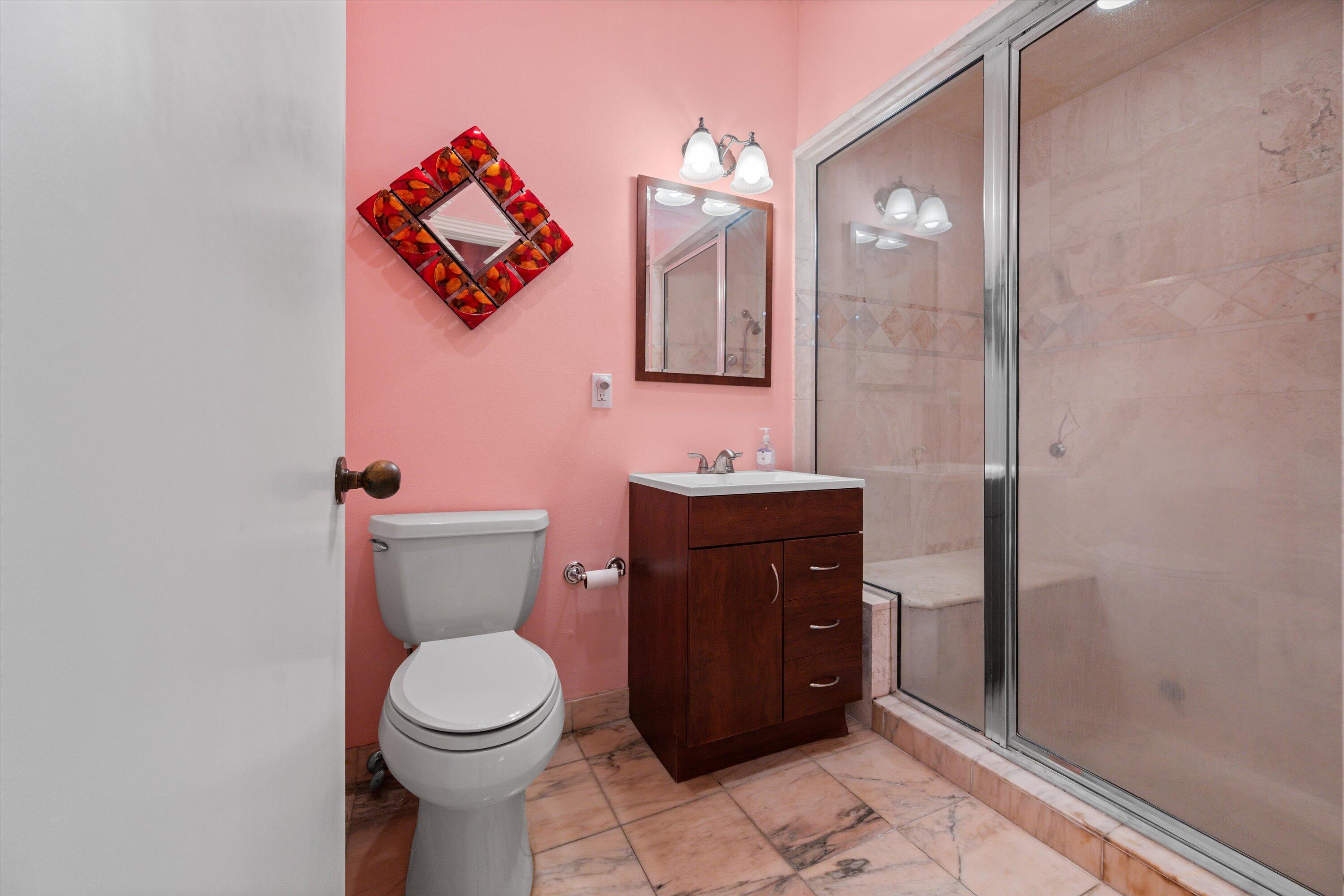 1535 Fairway Terrace West Palm Beach, FL 33411 - Photo 16 of 47 a bathroom with a toilet sink vanity and mirror