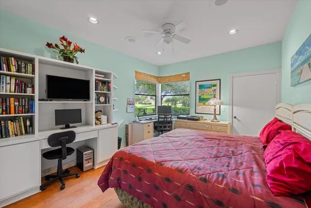 a bed room with a bed a television and a book shelf