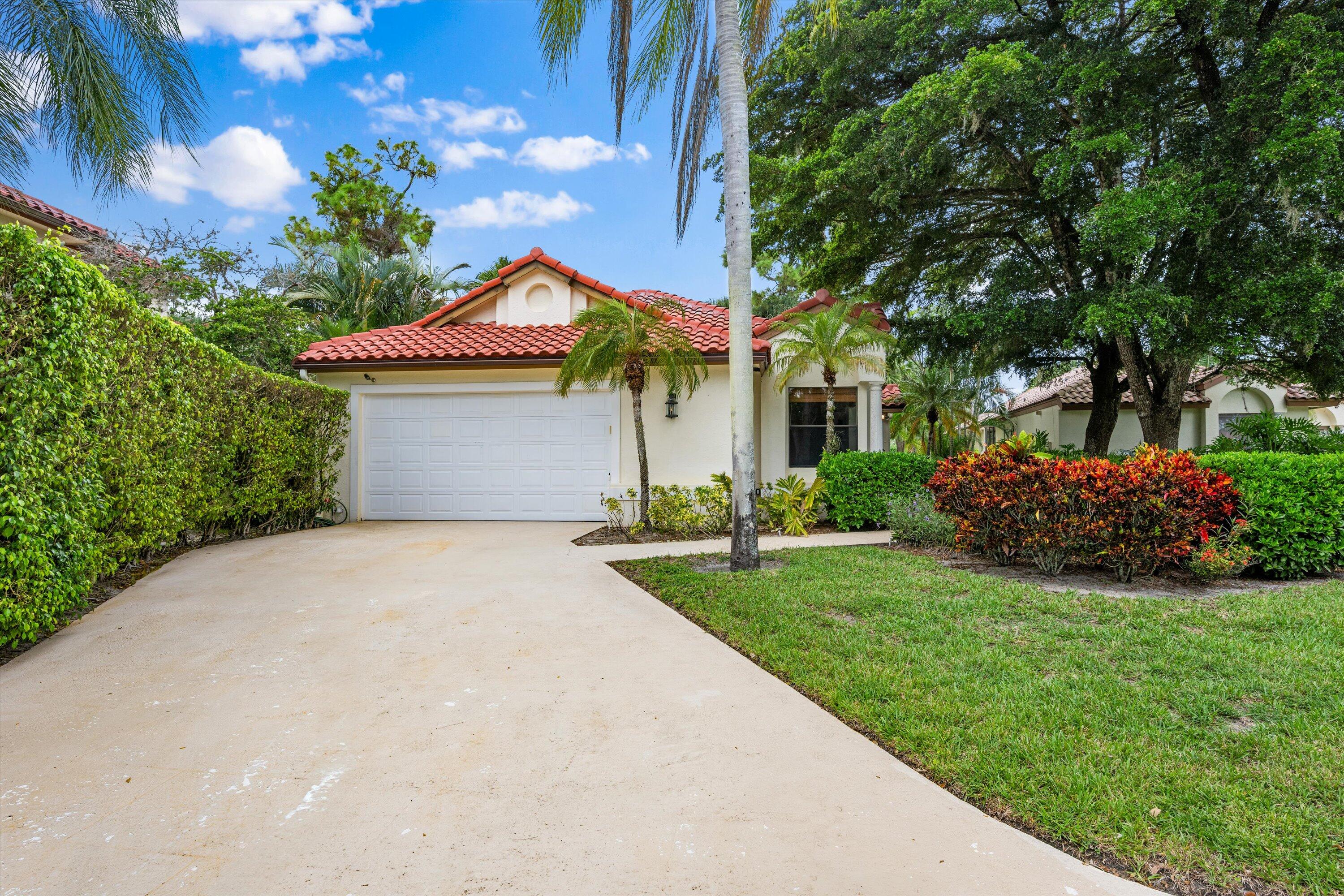 1535 Fairway Terrace West Palm Beach, FL 33411 - Photo 2 of 47 a front view of a house with a garden and yard