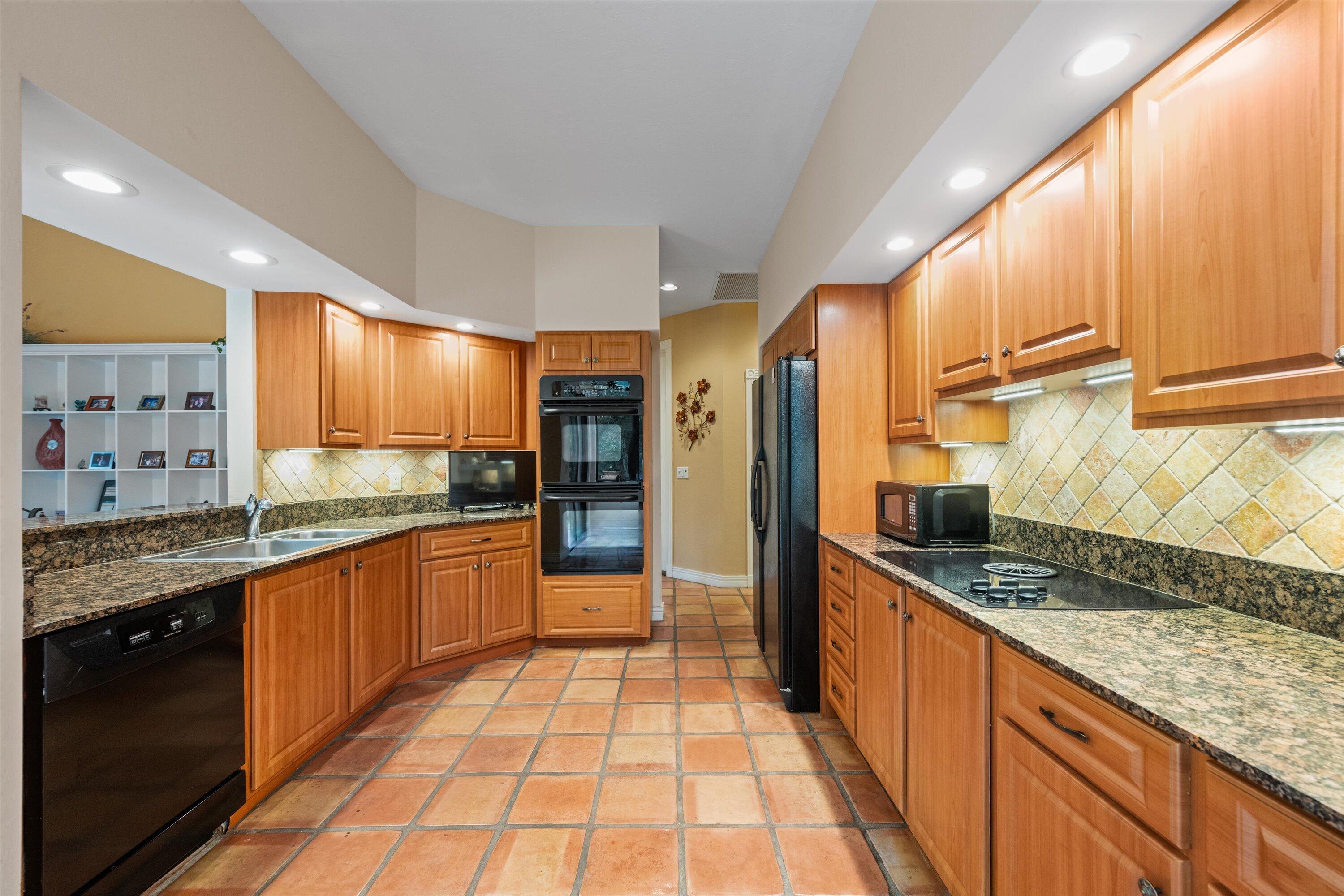 1535 Fairway Terrace West Palm Beach, FL 33411 - Photo 8 of 47 a large kitchen with stainless steel appliances granite countertop a sink and cabinets