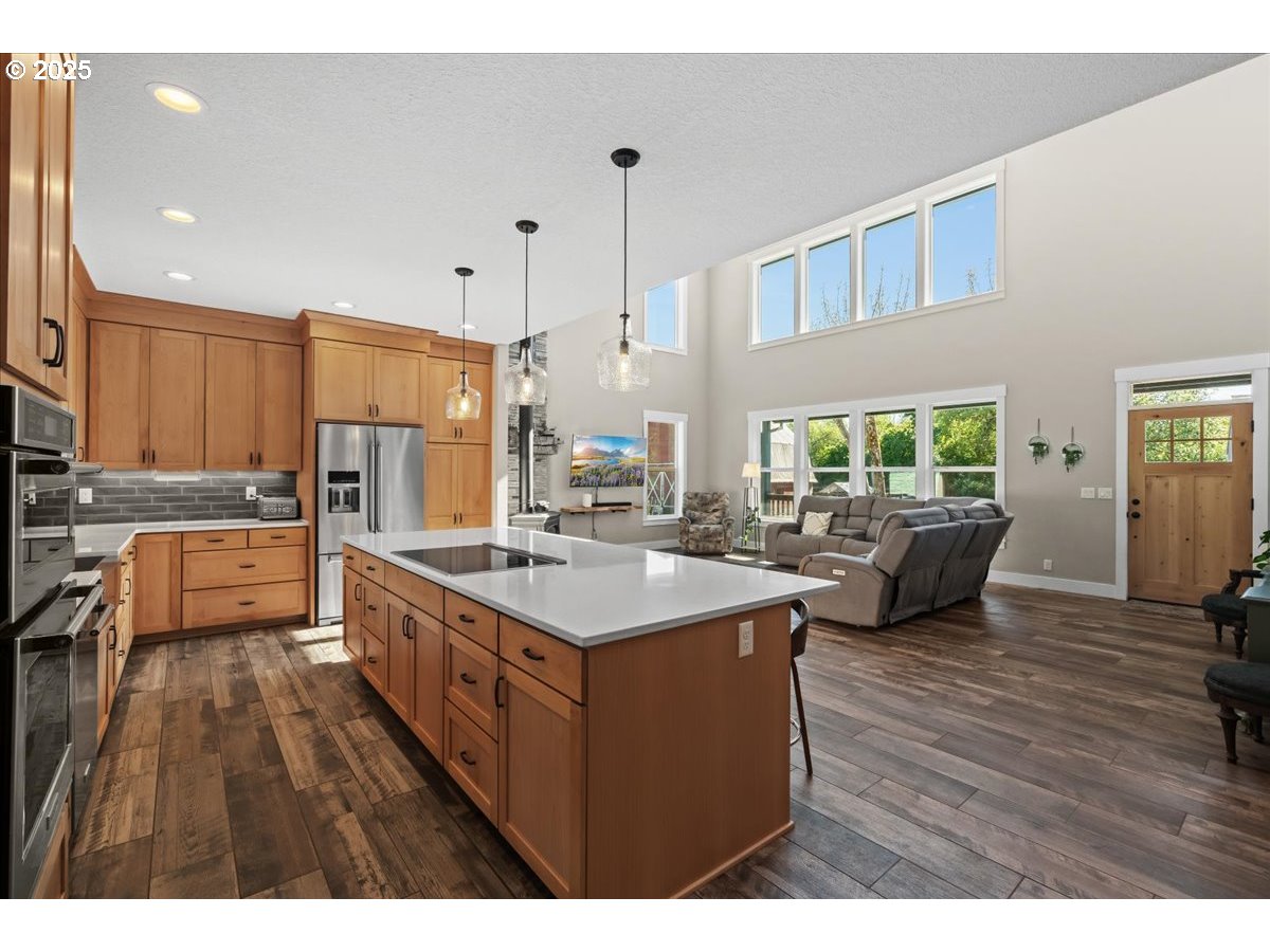 43300 Northwest Cedar Canyon Road Banks, OR 97106 - Photo 10 of 48 a open kitchen with stainless steel appliances kitchen island granite countertop a sink dishwasher a stove and a refrigerator with wooden floor