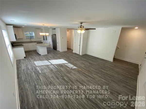 a view of a big room with wooden floor and windows