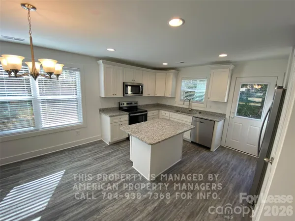 a kitchen with a sink a counter top space stainless steel appliances and a window
