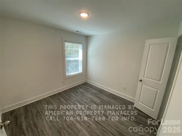 an empty room with wooden floor and window