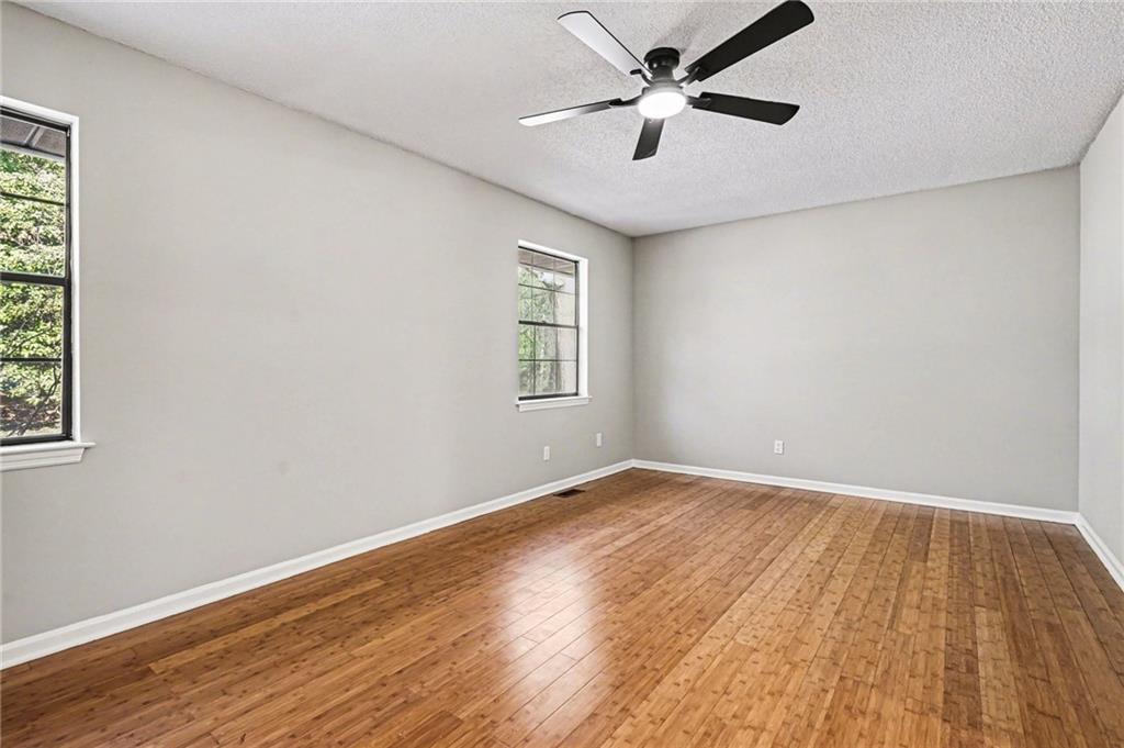 6052 WinterGreen Road Northwest Norcross, GA 30093 - Photo 14 of 24 a view of empty room with wooden floor and fan