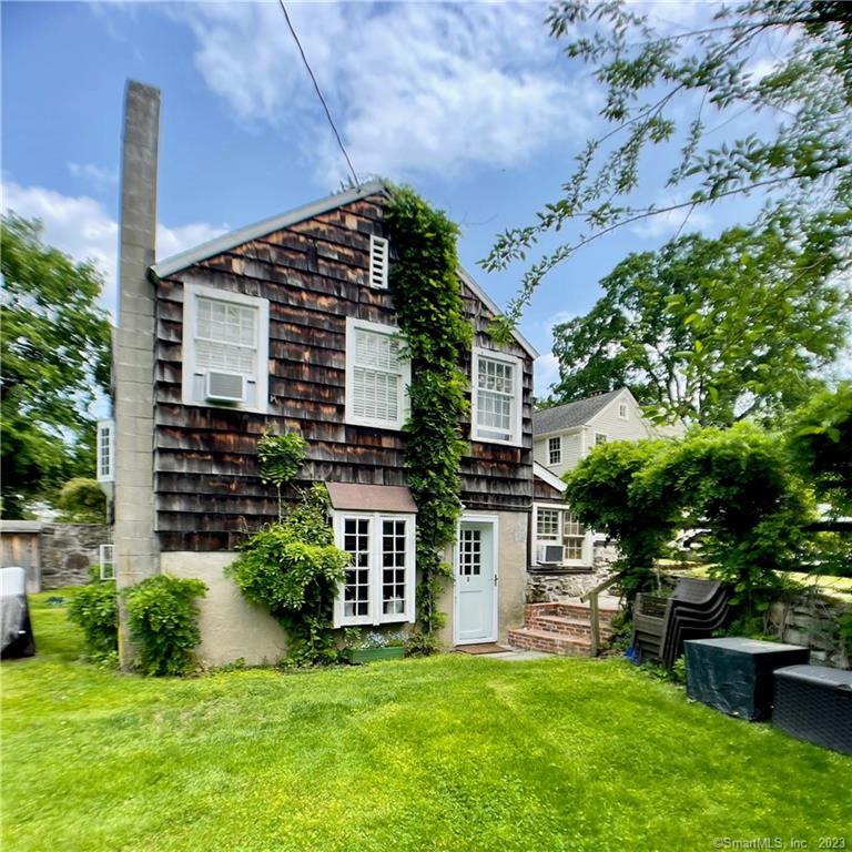 a view of a house with a yard and potted plants