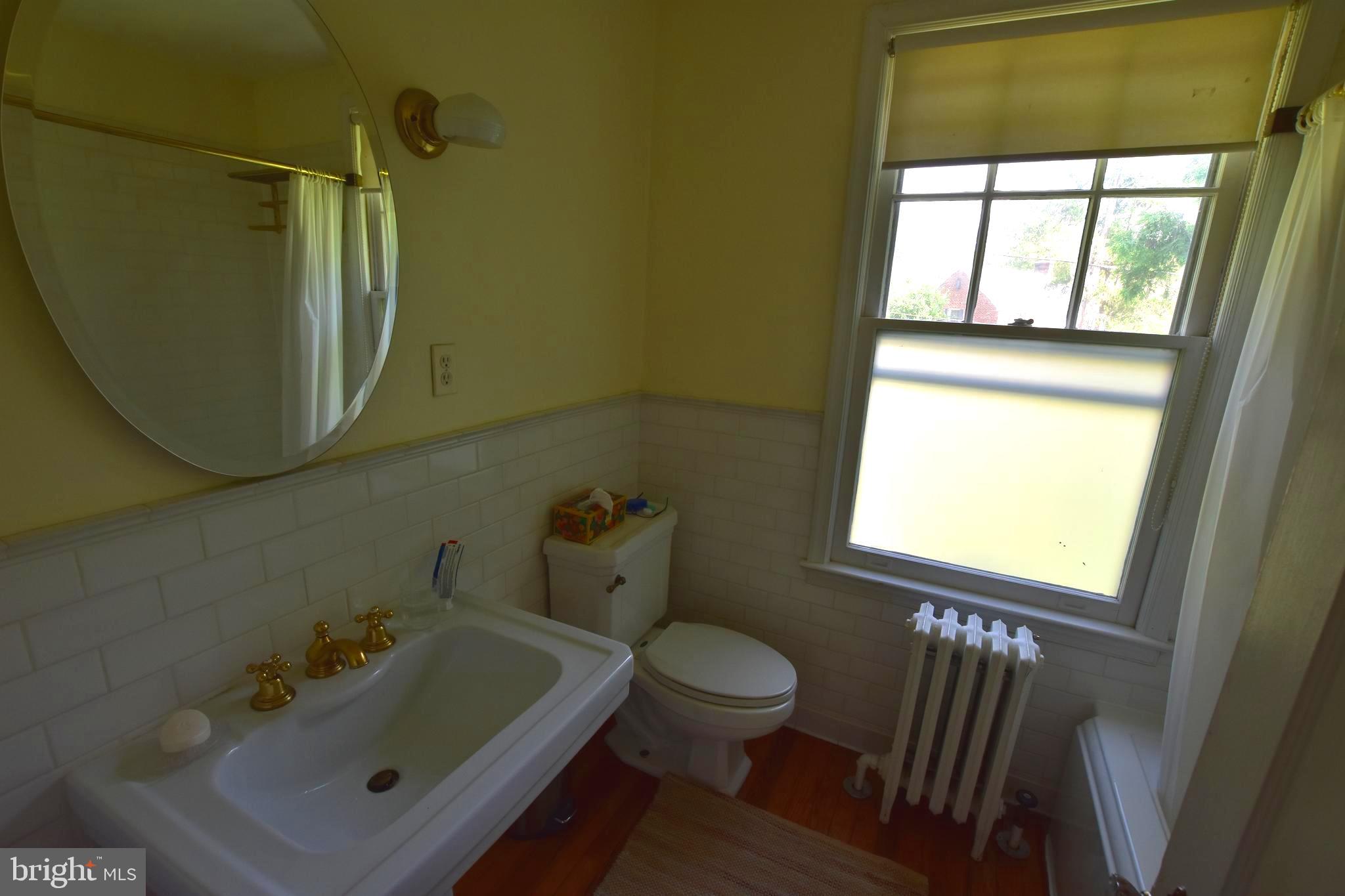 1300 Noyes Drive Silver Spring, MD 20910 - Photo 16 of 30 a bathroom with a sink a toilet and a mirror