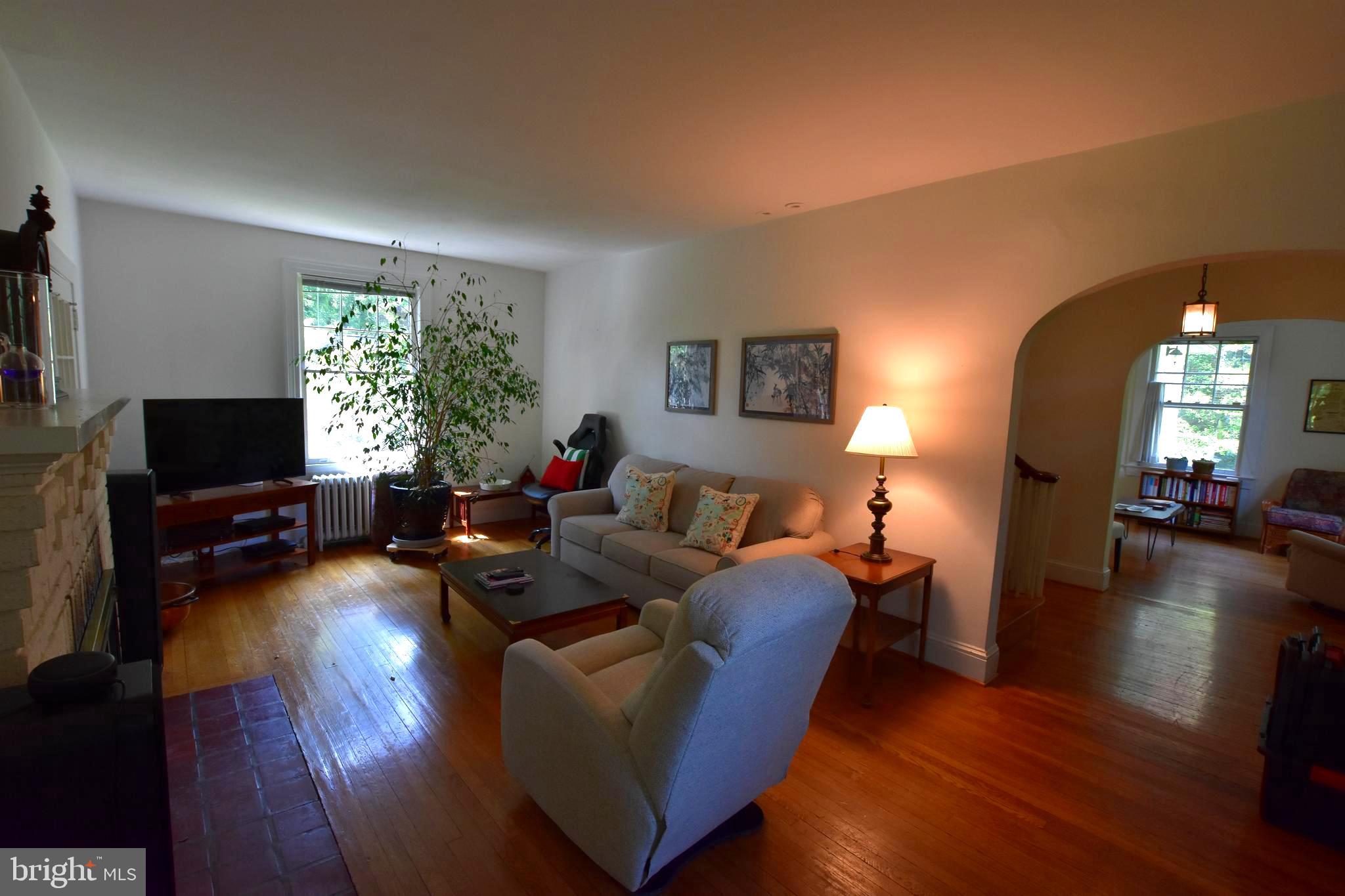 1300 Noyes Drive Silver Spring, MD 20910 - Photo 3 of 30 a living room with furniture a fireplace and a flat screen tv