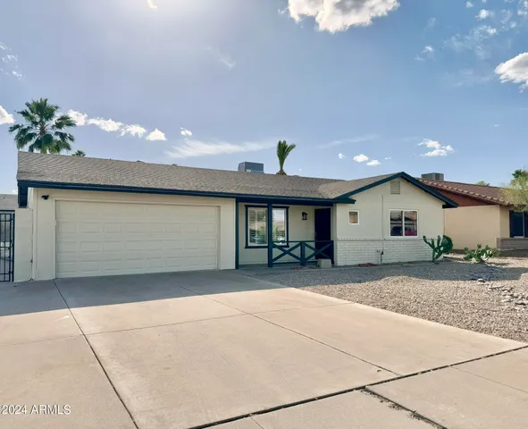 a view of a house with a patio and a yard