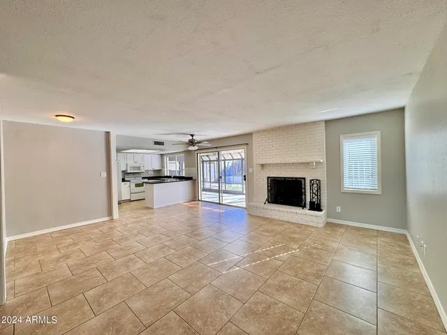 a view of an empty room with a fireplace and a window