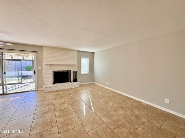a view of an empty room with a fireplace and a window