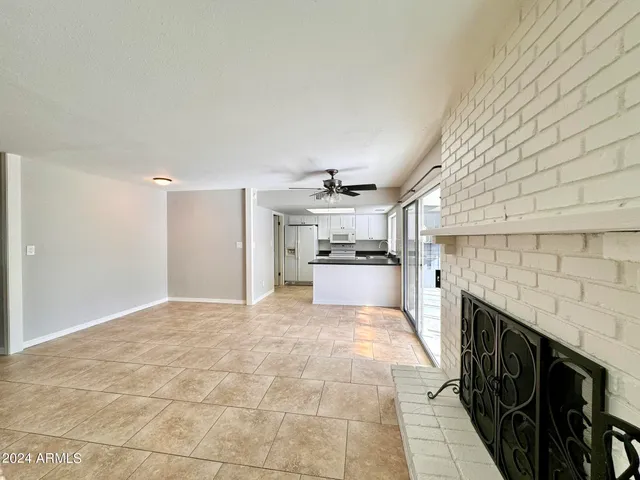 a kitchen with granite countertop a refrigerator a sink and white cabinets
