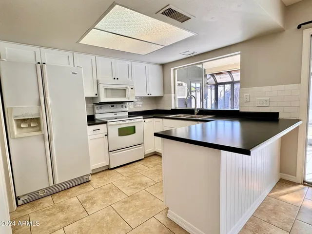 a kitchen with granite countertop white cabinets and white appliances