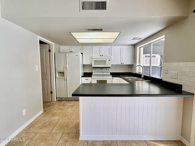 a kitchen with stainless steel appliances granite countertop a sink and a refrigerator