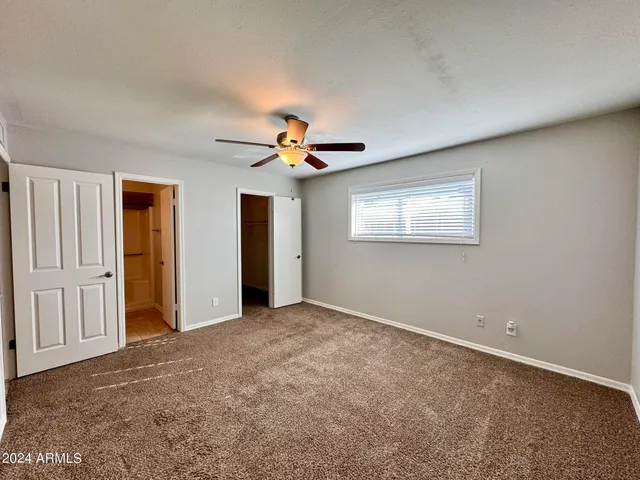 a view of an empty room with a ceiling fan