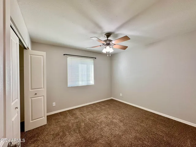 a view of a big room with closet and a chandelier fan