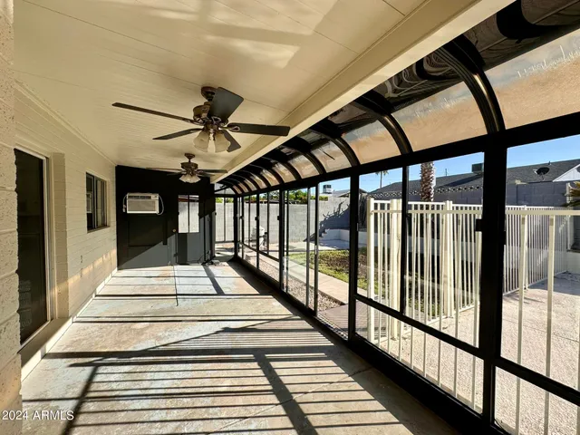 a view of a porch with a floor to ceiling window and wooden fence
