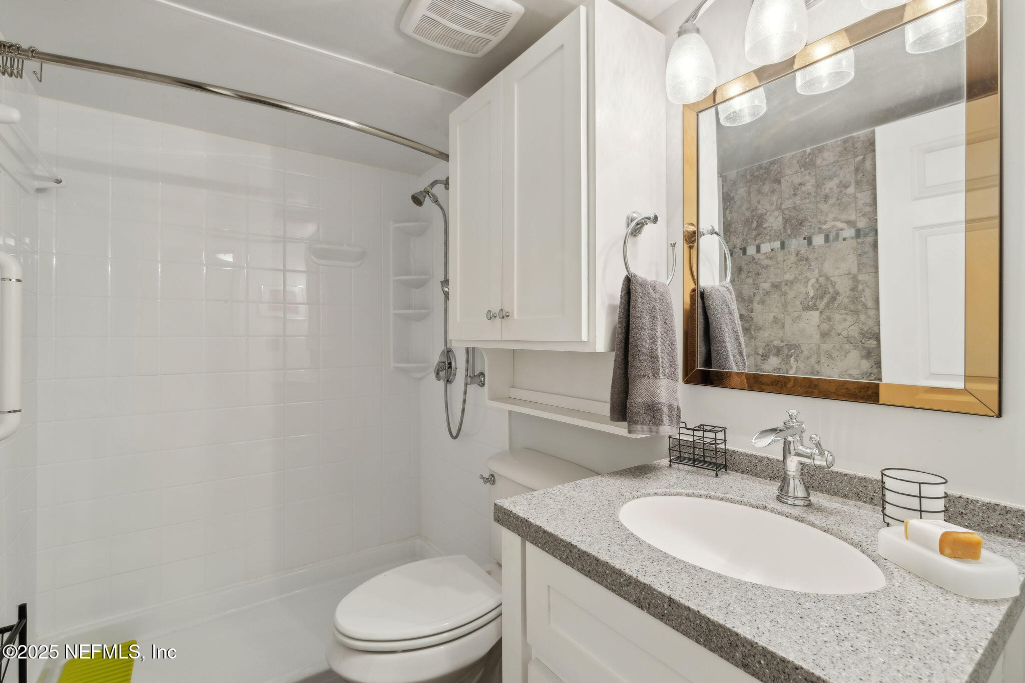 210 River Bend Court, Unit B Welaka, FL 32193 - Photo 18 of 41 a bathroom with a granite countertop sink toilet a mirror a vanity and shower