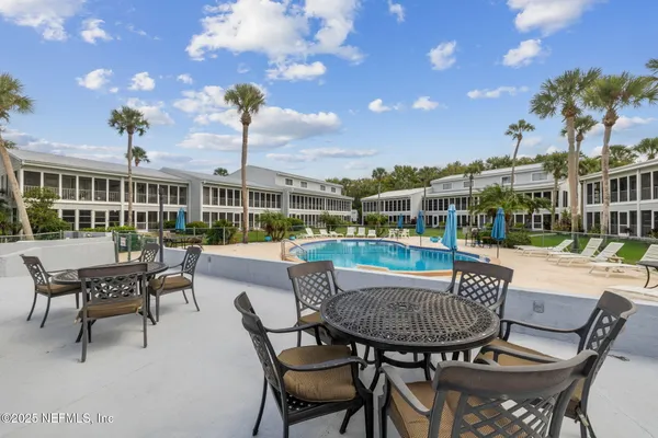 a view of a swimming pool with a lawn chairs and plants