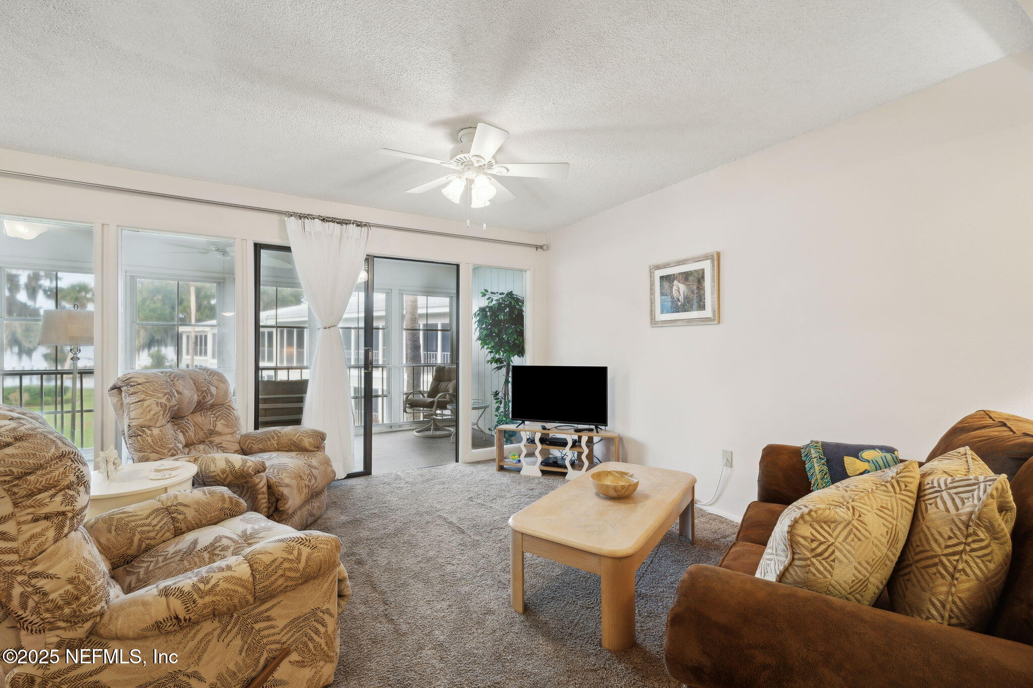 210 River Bend Court, Unit B Welaka, FL 32193 - Photo 6 of 41 a living room with furniture a ceiling fan and a flat screen tv