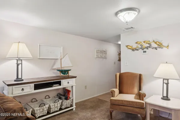 a living room with furniture a ceiling fan and a flat screen tv