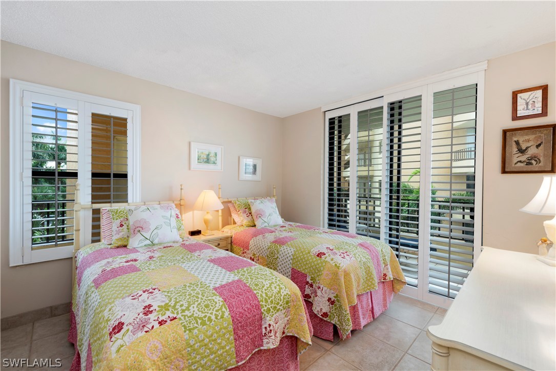 15021 Punta Rassa Road, Unit 201 Fort Myers, FL 33908 - Photo 8 of 29 a bedroom with two beds and a large window