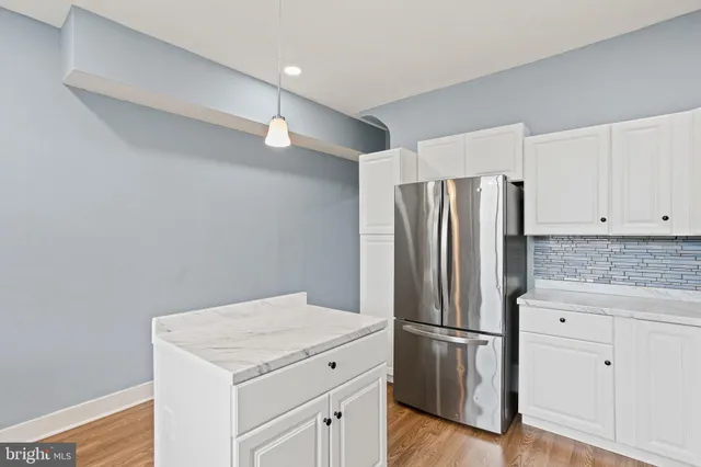 a kitchen with a refrigerator sink and cabinets