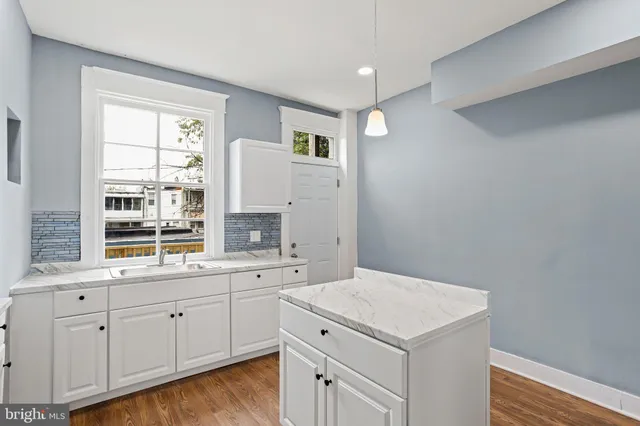 a kitchen with a sink cabinets and wooden floor