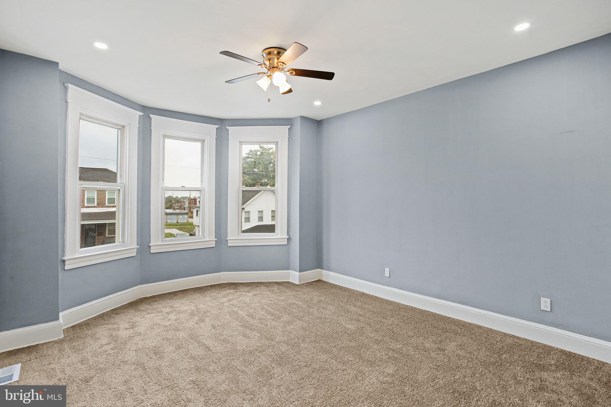 2811 Erdman Avenue Baltimore, MD 21213 - Photo 14 of 31 an empty room with windows and chandelier fan