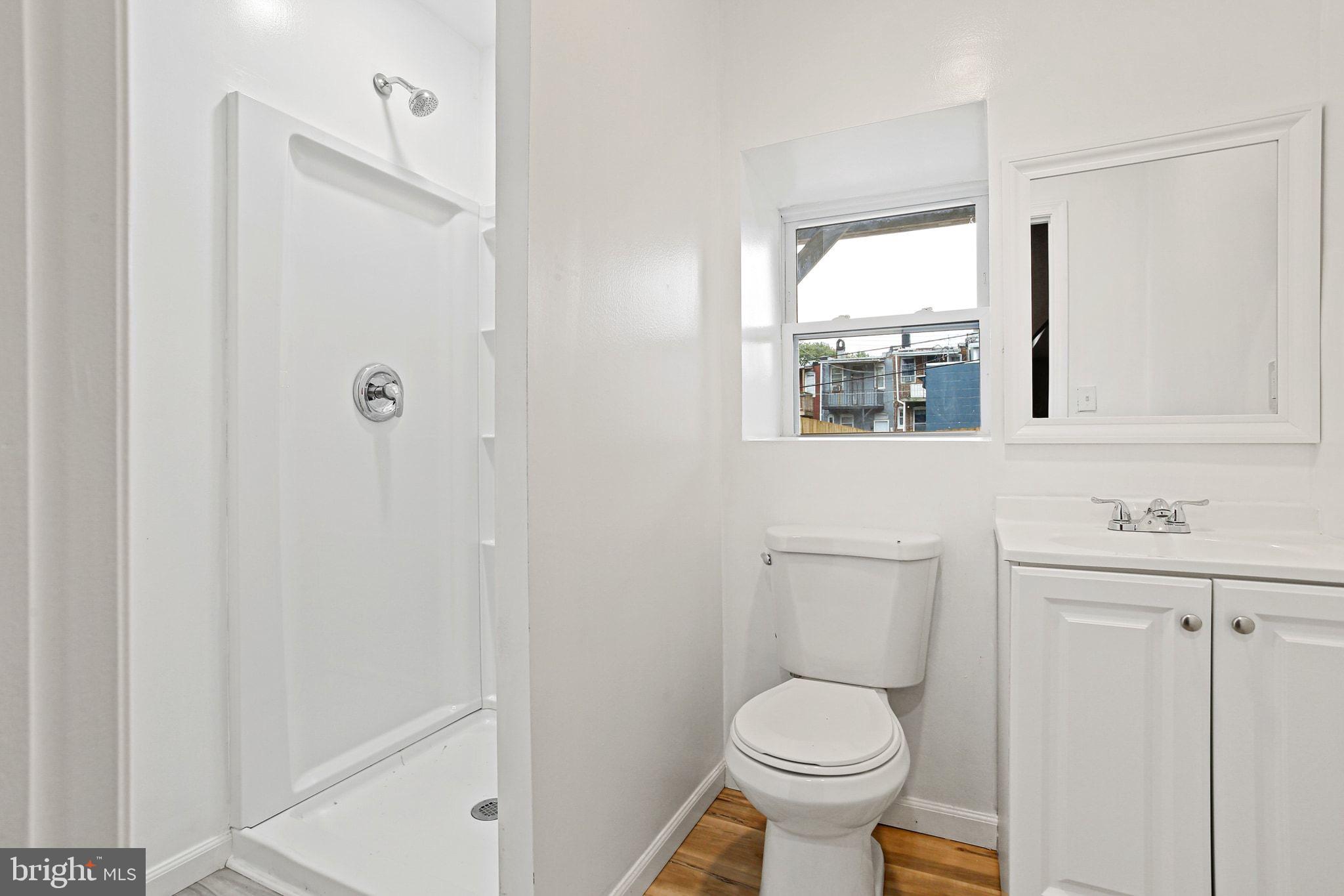 2811 Erdman Avenue Baltimore, MD 21213 - Photo 28 of 31 a bathroom with a toilet a sink a window and mirror