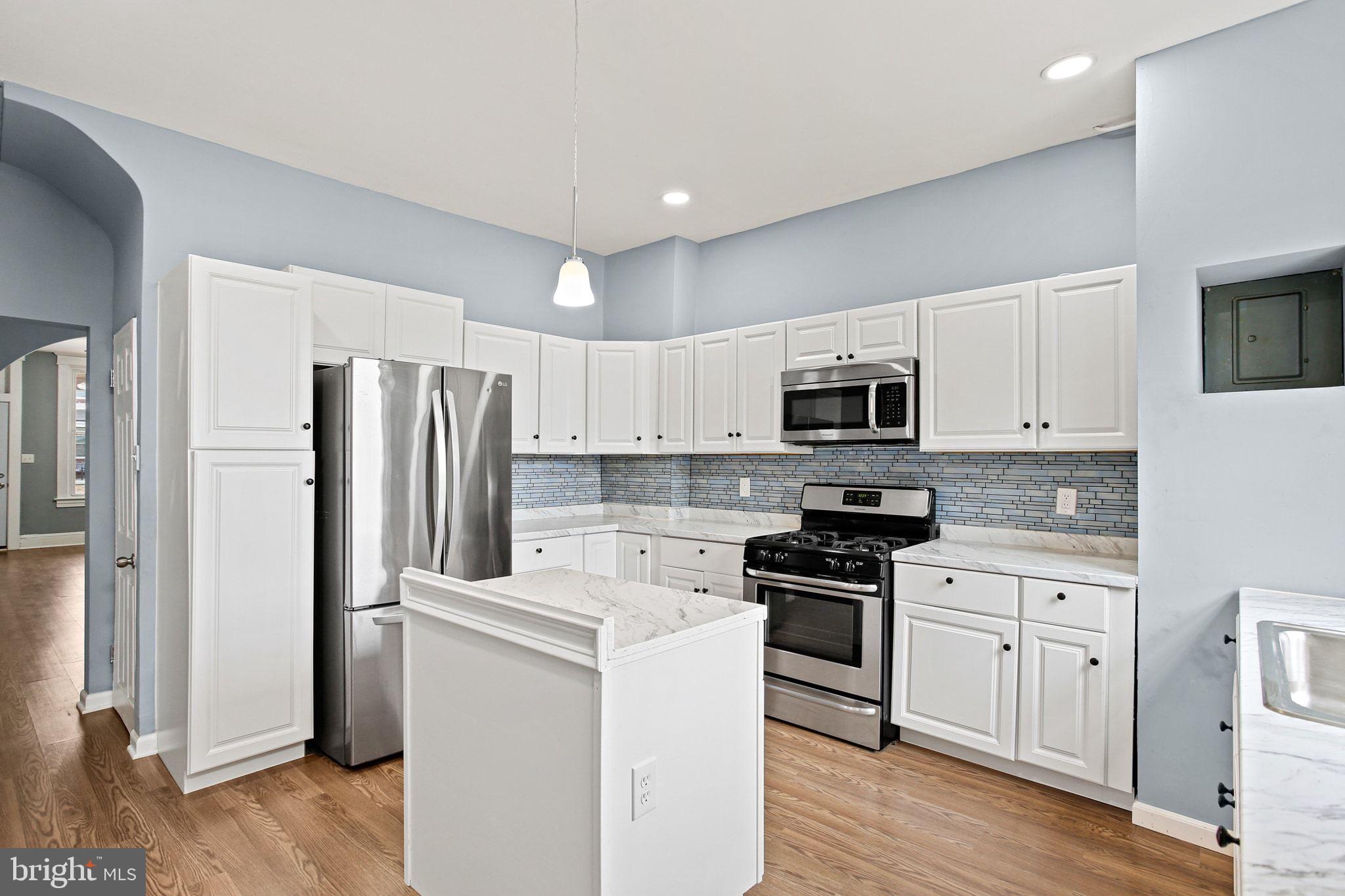 2811 Erdman Avenue Baltimore, MD 21213 - Photo 10 of 31 a kitchen with white cabinets and stainless steel appliances
