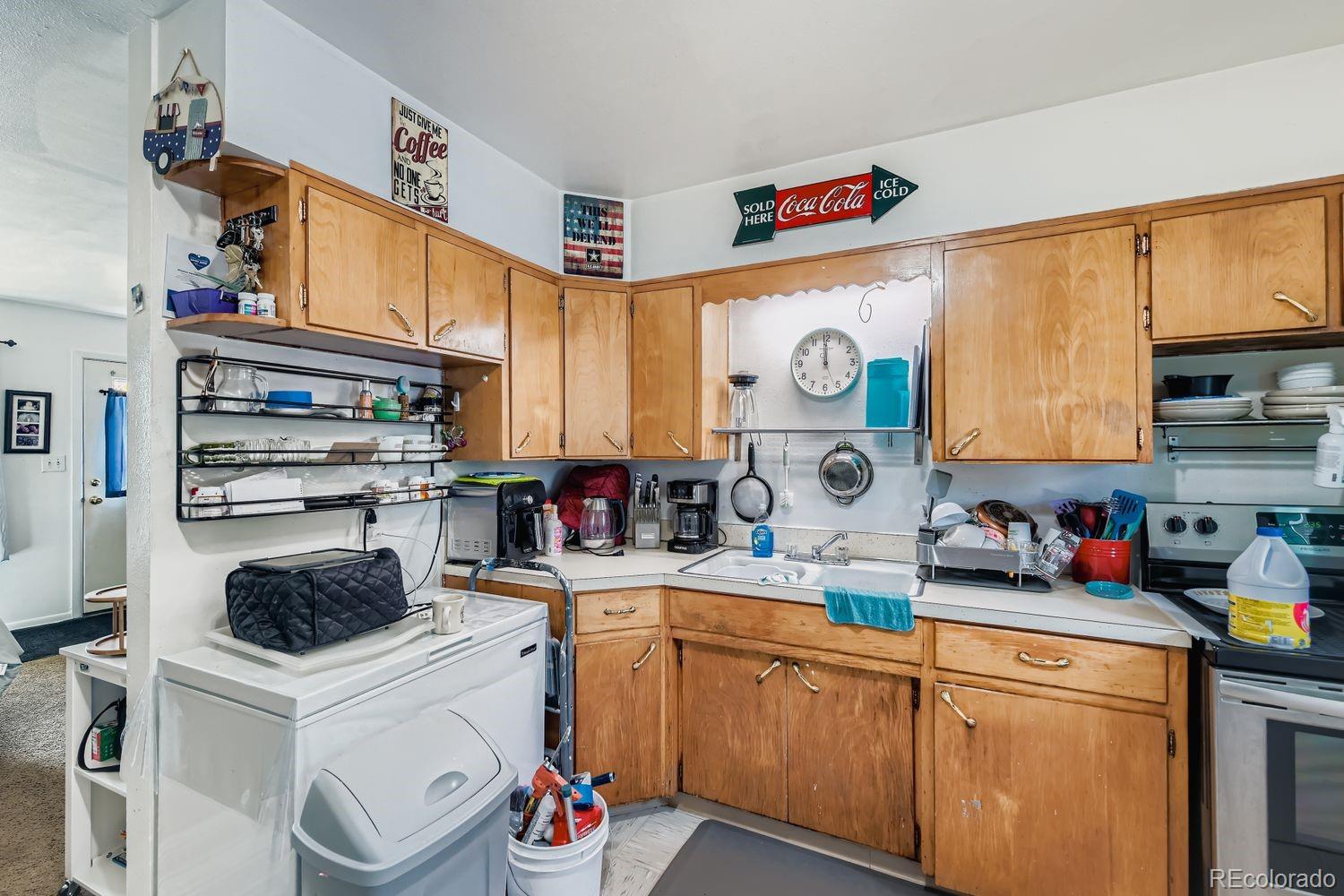 315 6th Street Fort Lupton, CO 80621 - Photo 11 of 26 a kitchen with a sink a stove and cabinets