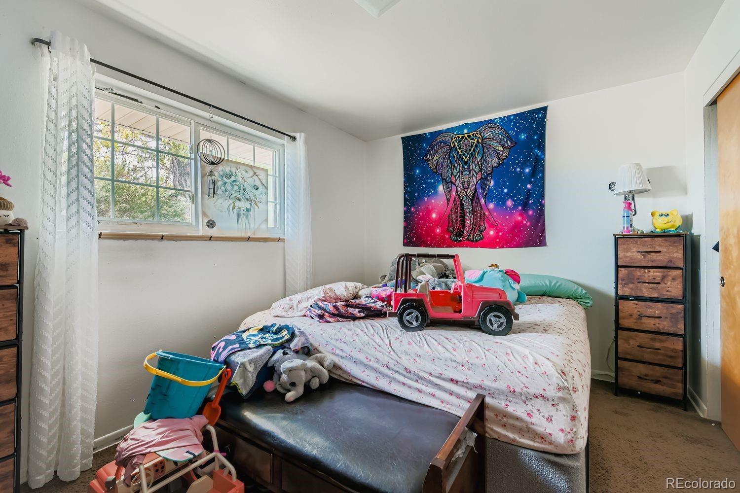 315 6th Street Fort Lupton, CO 80621 - Photo 12 of 26 a bedroom with a bed a baby desk and chair