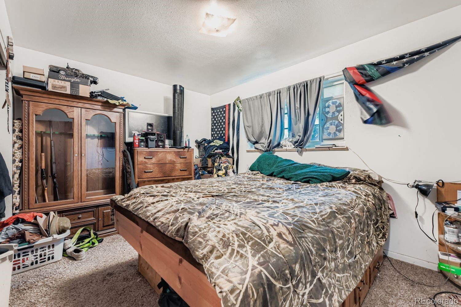 315 6th Street Fort Lupton, CO 80621 - Photo 18 of 26 a bed sitting in a bedroom next to a window