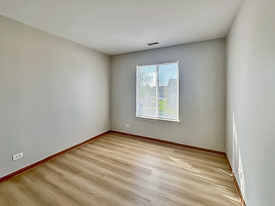 637 Deames Street Plano, IL 60545 - Photo 13 of 18 wooden floor in an empty room with a window