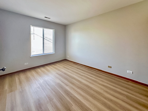 637 Deames Street Plano, IL 60545 - Photo 16 of 18 a view of an empty room with wooden floor and a window