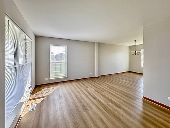 637 Deames Street Plano, IL 60545 - Photo 2 of 18 wooden floor in an empty room with a window