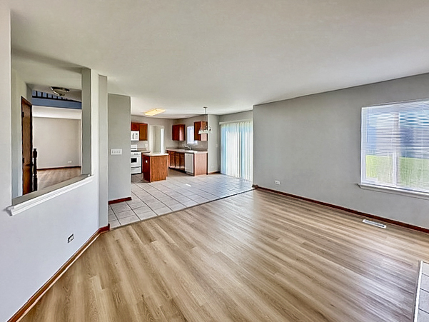 637 Deames Street Plano, IL 60545 - Photo 6 of 18 a view of a room with wooden floor and windows