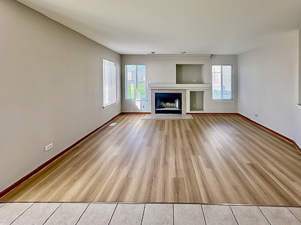 637 Deames Street Plano, IL 60545 - Photo 7 of 18 a view of empty room with wooden floor and fireplace