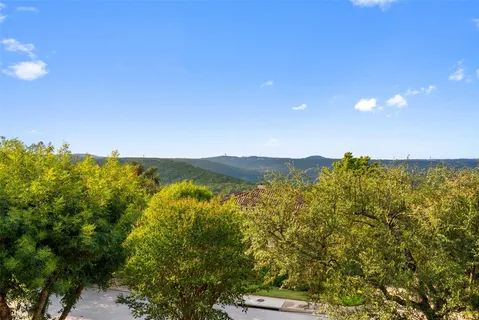 a view of swimming pool with outdoor seating and trees in the background