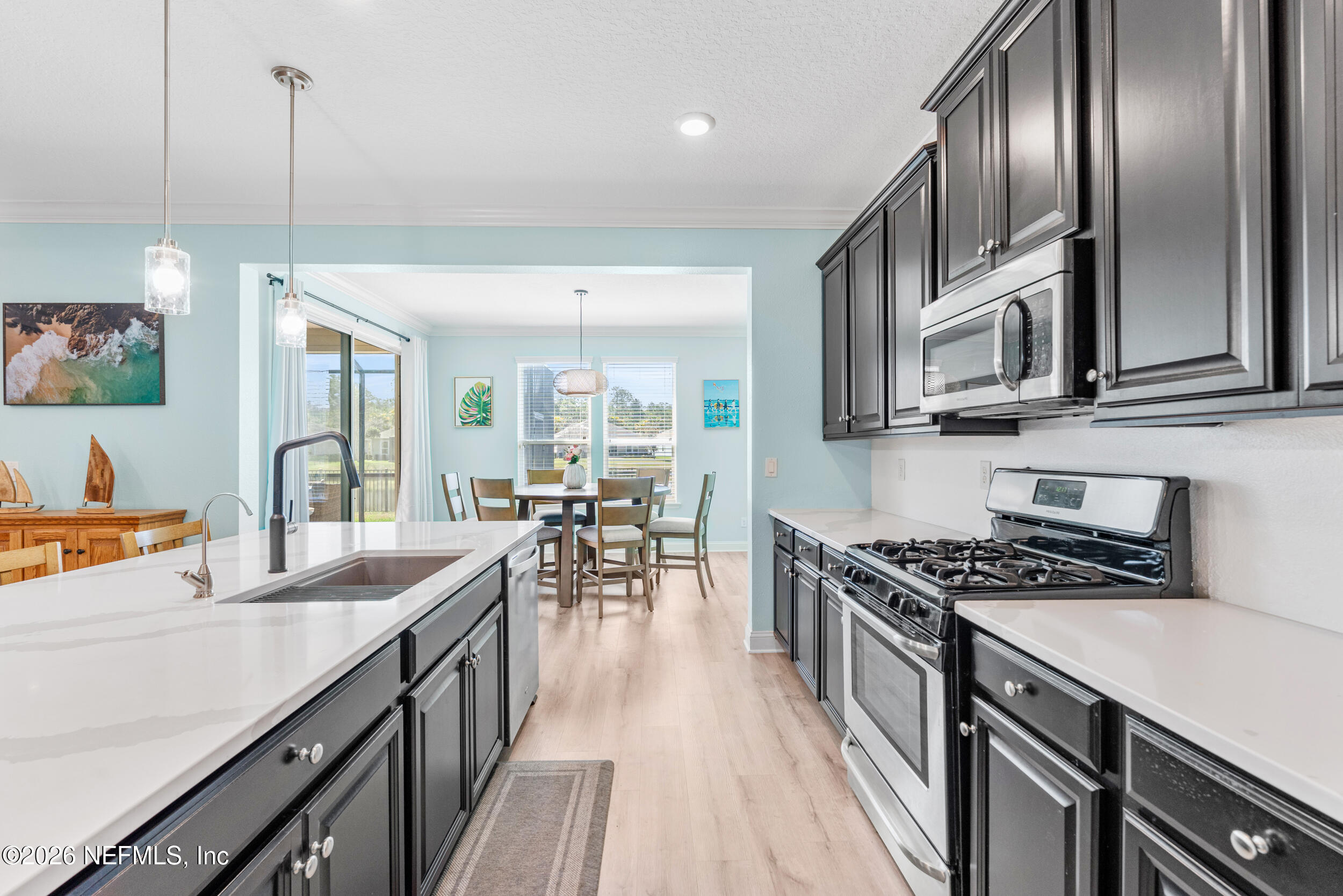168 St Kitts Loop St. Augustine, FL 32092 - Photo 21 of 47 a kitchen with stainless steel appliances granite countertop a sink a stove and a wooden floors