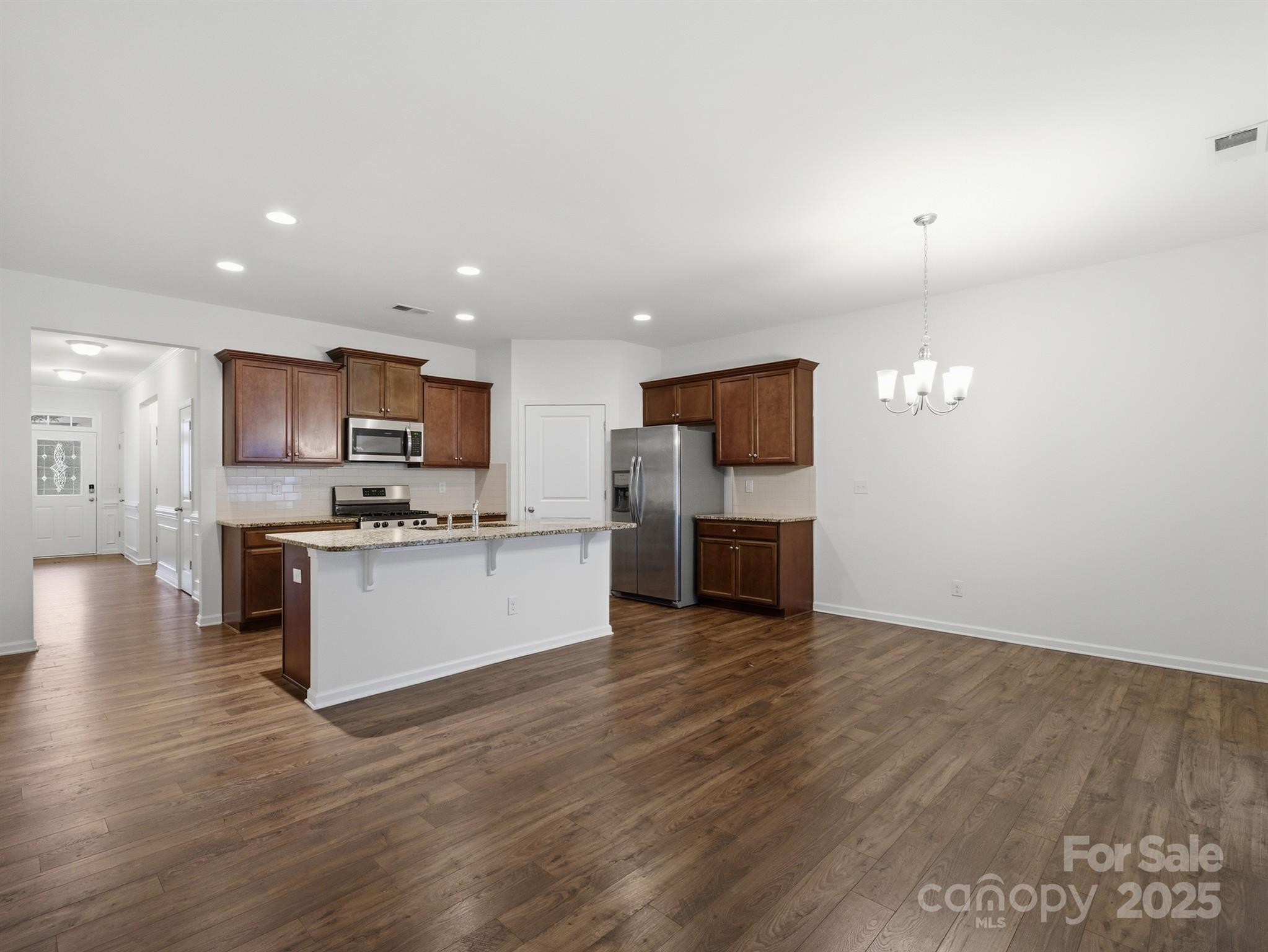 2212 Apple Glen Lane Charlotte, NC 28269 - Photo 11 of 32 a kitchen with stainless steel appliances kitchen island granite countertop a stove top oven a sink dishwasher a refrigerator and white cabinets with wooden floor