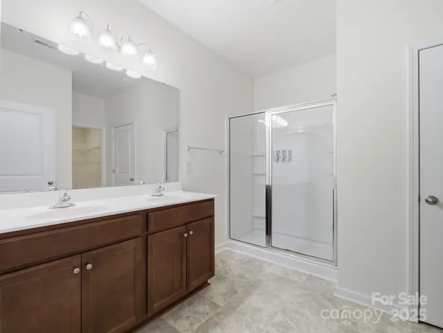 a bathroom with a double vanity sink mirror and shower